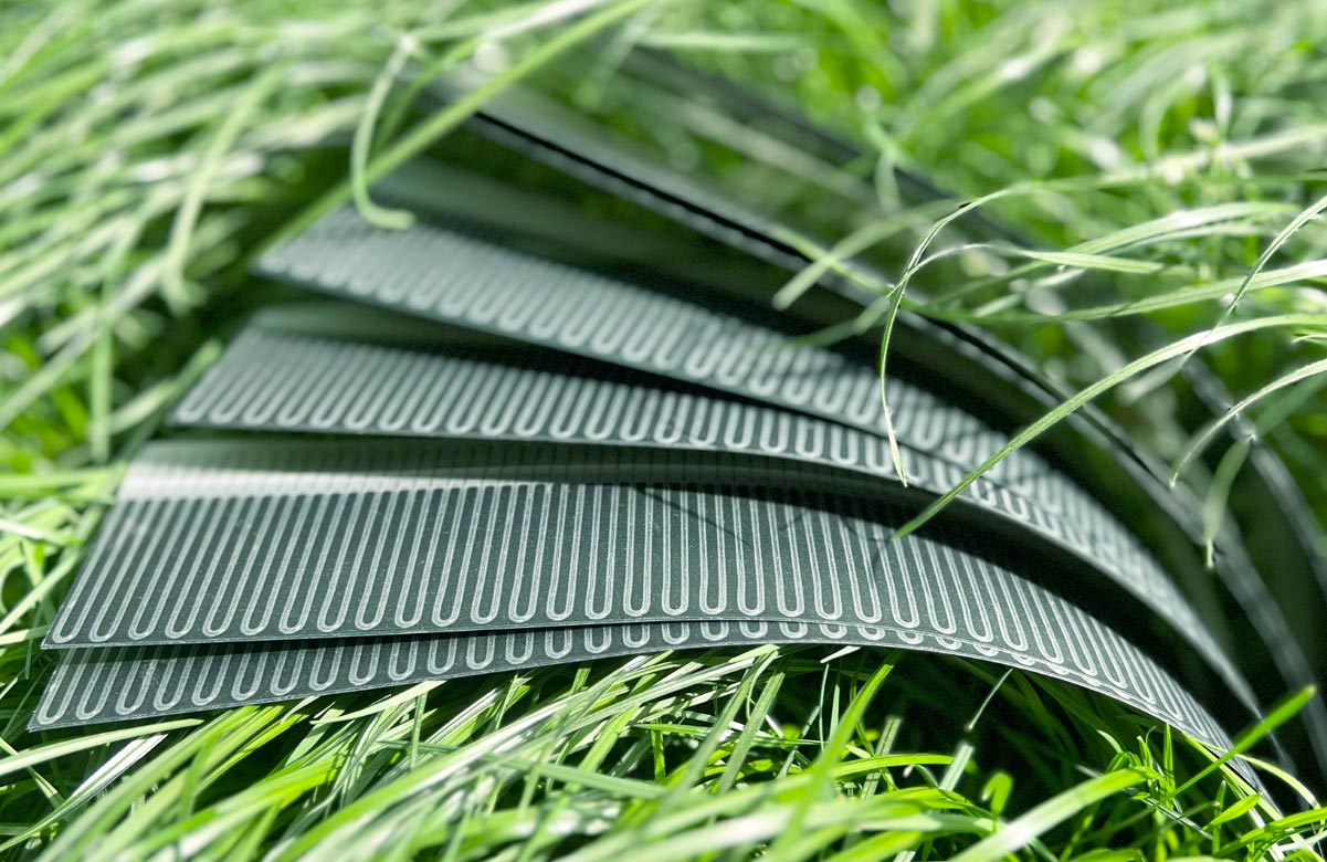 Elastyczne panele fotowoltaiczne zamontowane na zakrzywionym dachu budynku pochłaniające promienie słoneczne